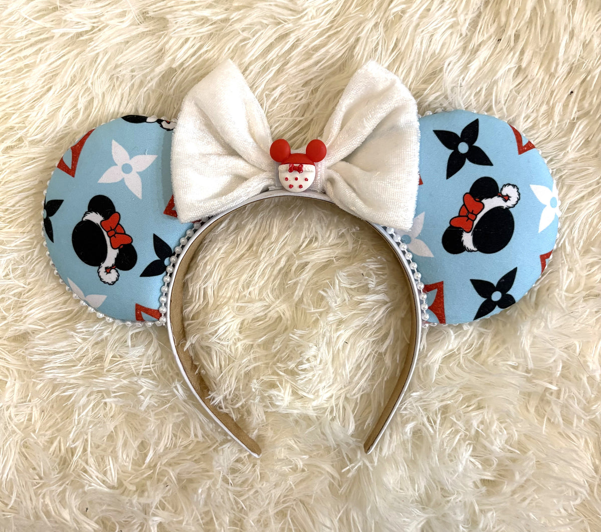 Frosted Holiday Magic Boutique mouse ear headband featuring icy blue Christmas fabric, white pearl-beaded trim, oversized white bow and festive red centerpiece.