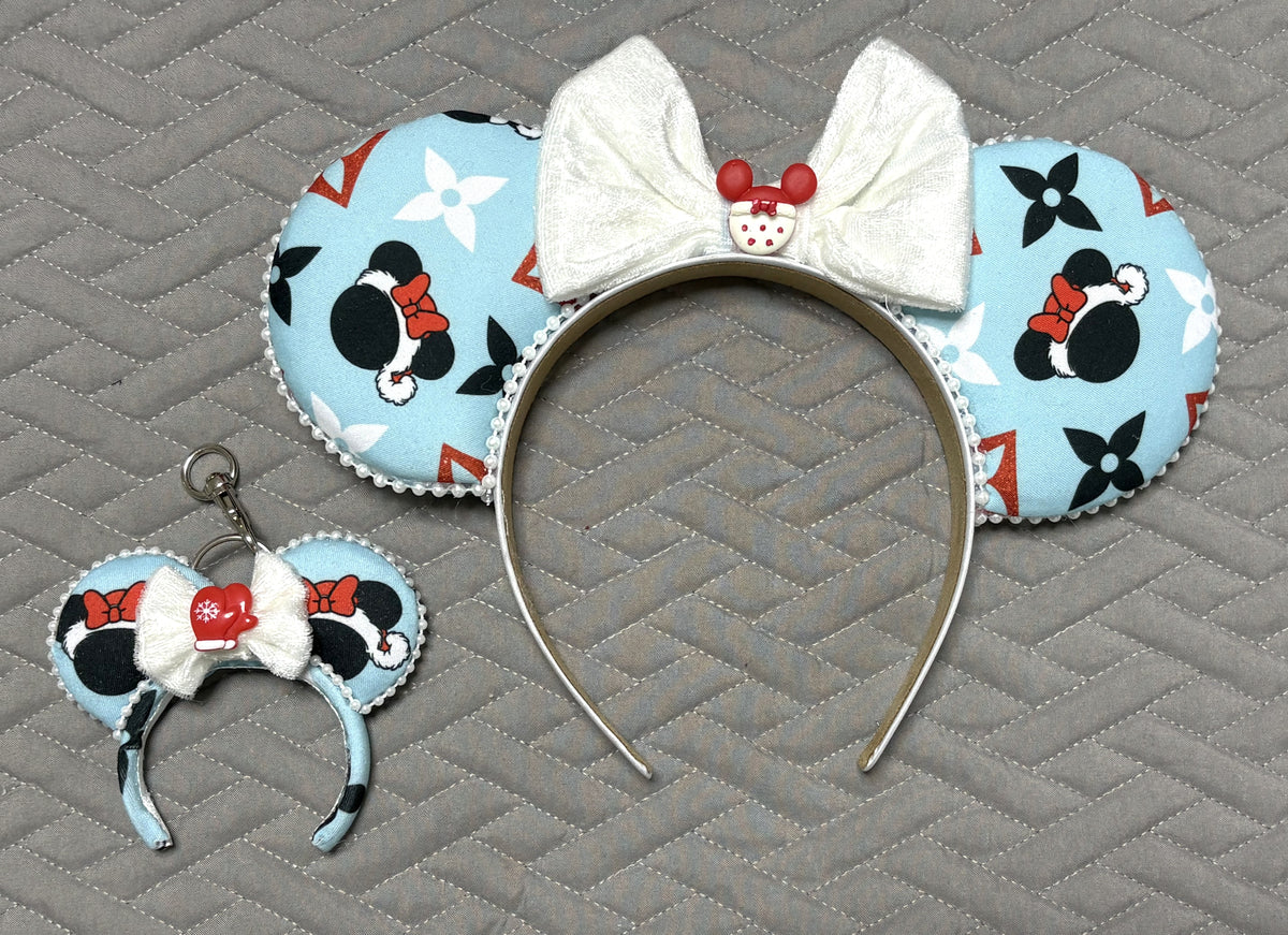 Frosted Holiday Magic Pixie Pair featuring a handcrafted icy blue Christmas mouse ear headband with pearl trim, oversized white bow, and matching mini ear bag charm with red mitten accent.