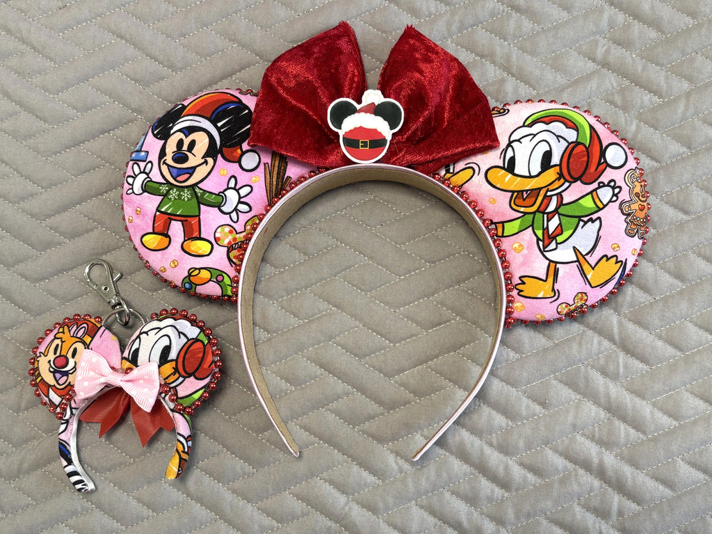 Jolly Holiday Friends Pixie Pair Set featuring a handcrafted Christmas mouse ear headband with ruby-red velvet bow, Santa-inspired centerpiece, sparkling red bead trim, and matching mini ear bag charm.