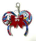 Christmas Castle Wishes miniature mouse ear keychain and bag charm with colorful castle fabric, red glitter poinsettia, gold bead trim, tiny jingle bells, and silver lobster clasp.
