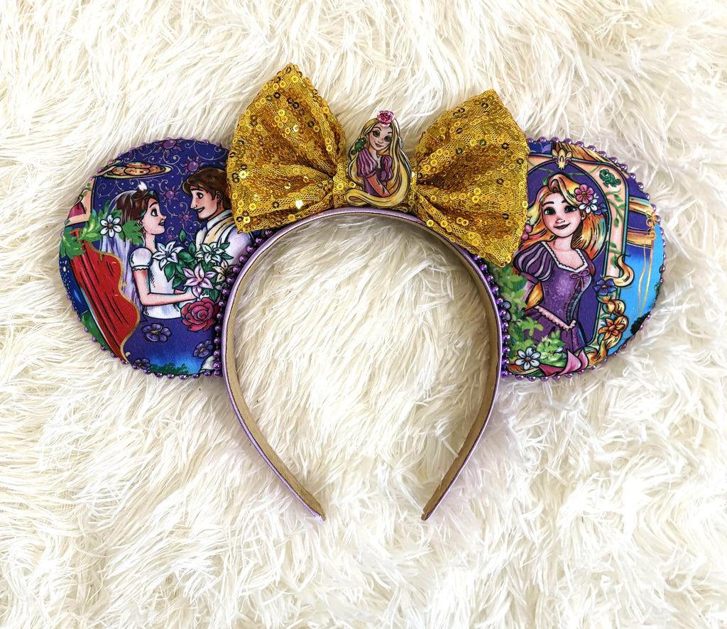 Handcrafted Golden Tower princess-inspired mouse ear headband with purple storybook ears, purple beaded trim, gold sequin bow and princess centerpiece.