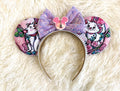 Pixie Park Company Couture Cats Signature handcrafted mouse ear headband featuring pastel Paris-inspired kitten artwork, a lavender sequin boutique bow, white beaded trim, and handcrafted boutique styling.

